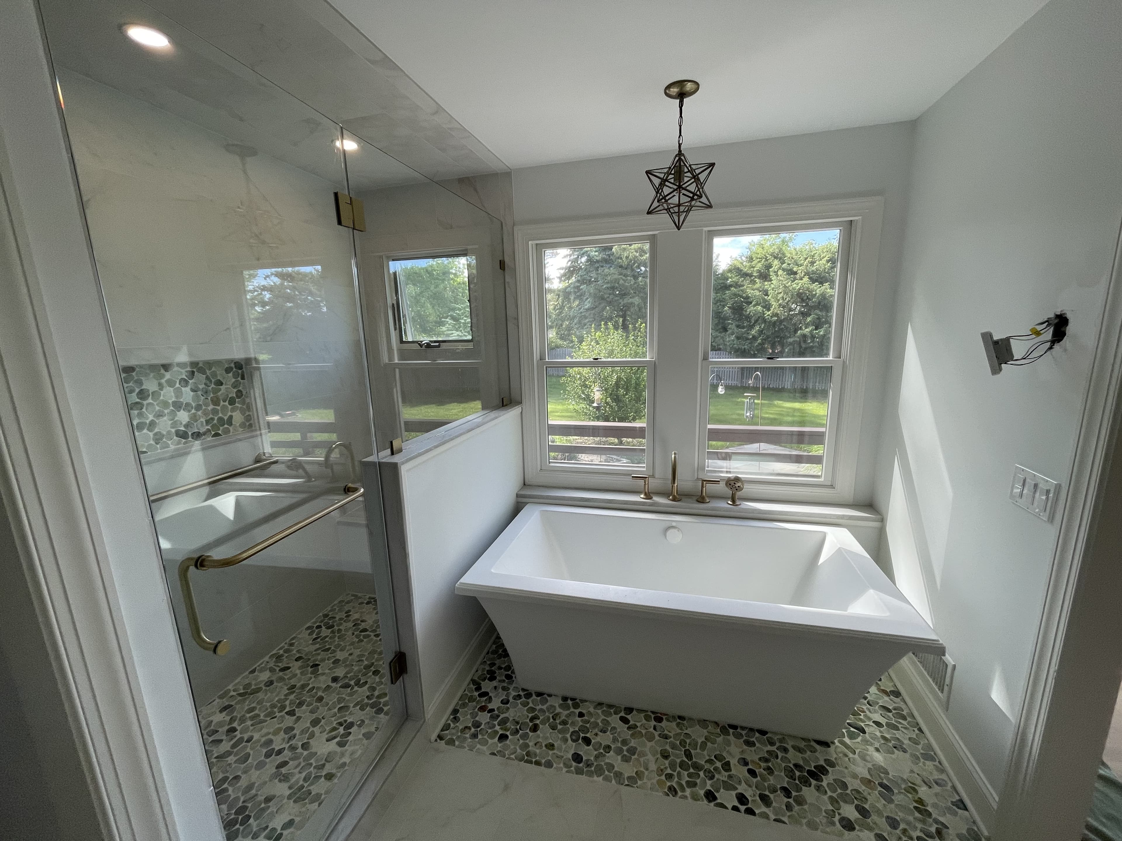 Master bathroom with freestanding soaking tub, pebble mosaic floor and gold fixtures — Oakhurst, NJ