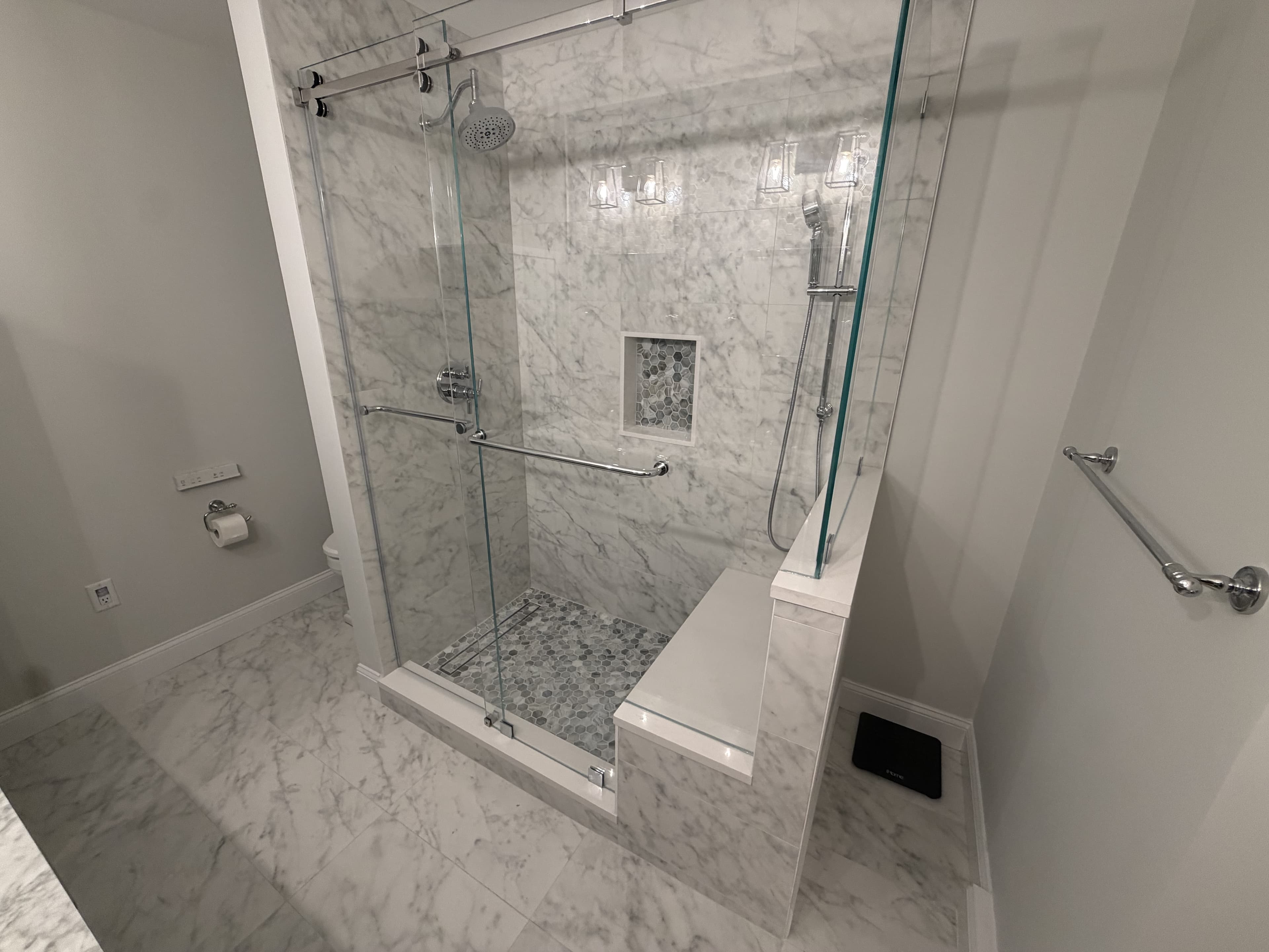 Marble shower with frameless sliding glass and bench seat — Atlantic Highlands, NJ