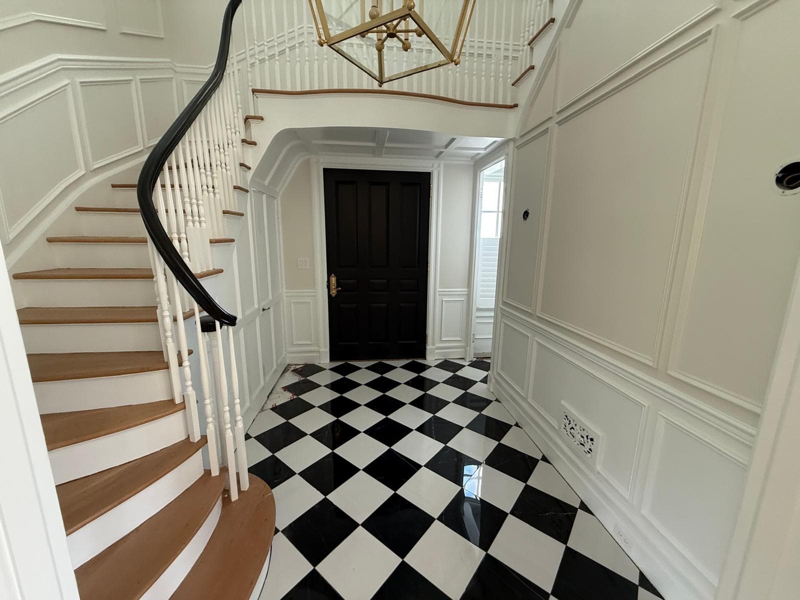 Grand curved staircase overlooking checker marble foyer from above — Little Silver, NJ